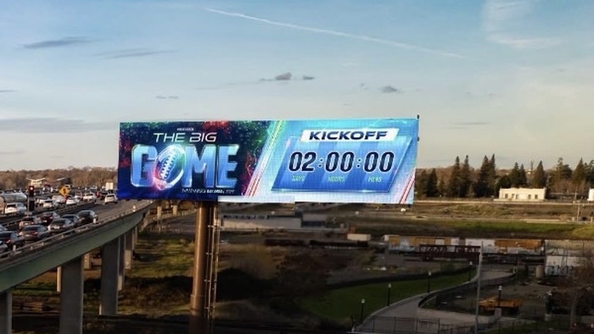 Highway digital billboard showing a live countdown timer to kickoff for The Big Game